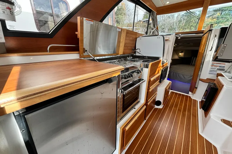  Yacht Photos Pics 2023 Cutwater C-32 Coupe interior with modern kitchen and cozy cabin.