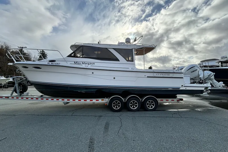 Yacht Photos Pics 2023 Cutwater C-32 Coupe boat on trailer under cloudy sky.
