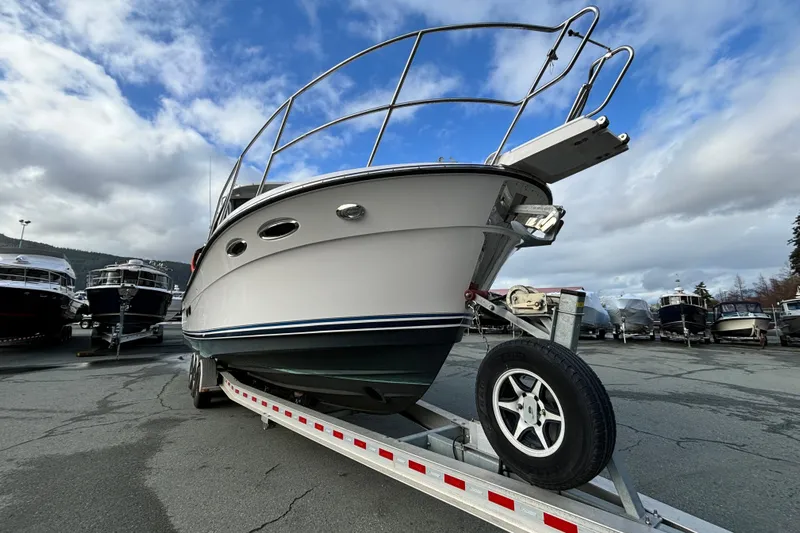  Yacht Photos Pics 2023 Cutwater C-32 Coupe boat on trailer under cloudy sky.