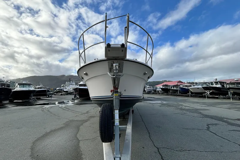  Yacht Photos Pics 2023 Cutwater C-32 Coupe boat on trailer, parked in marina under cloudy sky.