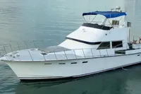 Custom 1984 Project yacht with blue canopy on calm water.