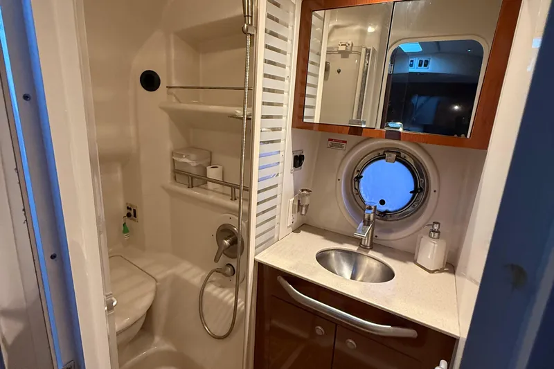  Yacht Photos Pics Bathroom interior of 2008 Sea Ray 350 Sundancer yacht with sink, mirror, and porthole.