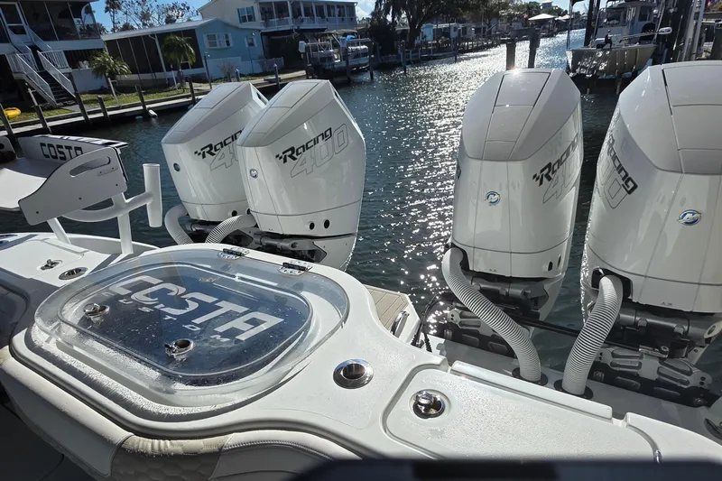 Wanderlust Yacht Photos Pics 2024 Costa Custom Boats 34 SV with four powerful outboard engines docked by the water.