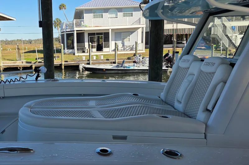 Wanderlust Yacht Photos Pics 2024 Costa Custom Boats 34 SV with luxurious seating docked near waterfront homes.