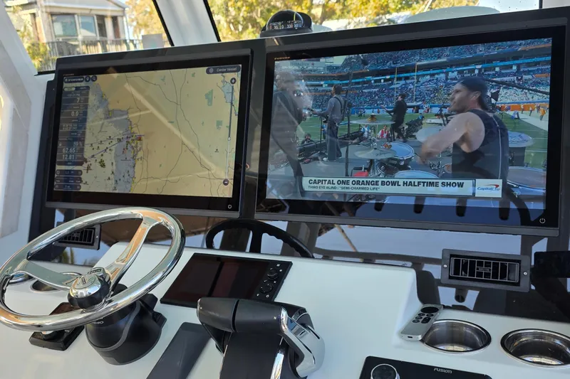 Wanderlust Yacht Photos Pics 2024 Costa Custom Boats 34 SV helm with dual screens displaying navigation and a live show.