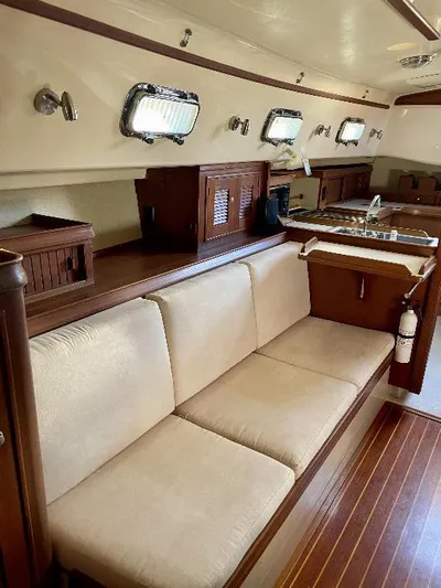  Yacht Photos Pics Interior of 1999 Island Packet 380 sailboat with wooden finishes and beige seating.