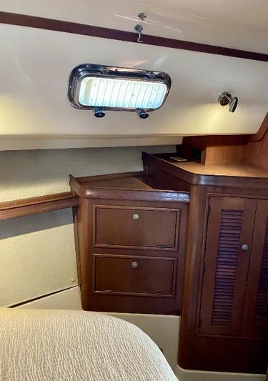  Yacht Photos Pics 1999 Island Packet 380 interior with wooden cabinetry and porthole window.