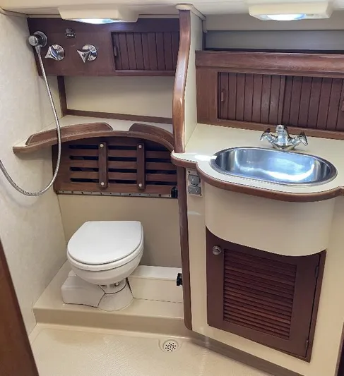  Yacht Photos Pics 1999 Island Packet 380 yacht bathroom with sink, toilet, and wooden cabinetry.