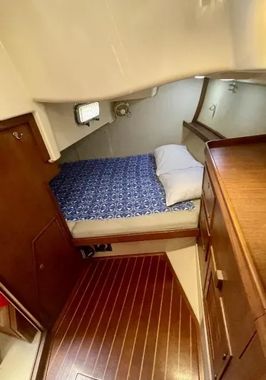  Yacht Photos Pics Cozy cabin interior of 1999 Island Packet 380 sailboat with wooden flooring and bed.