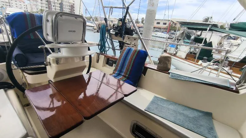  Yacht Photos Pics Cockpit of 1999 Island Packet 380 sailboat with wooden table and marina view.