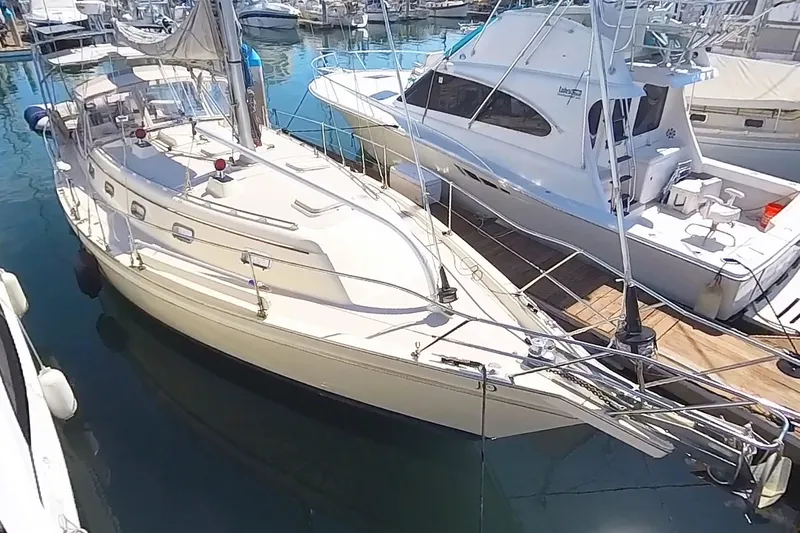  Yacht Photos Pics 1999 Island Packet 380 sailboat docked in a marina, alongside other boats.