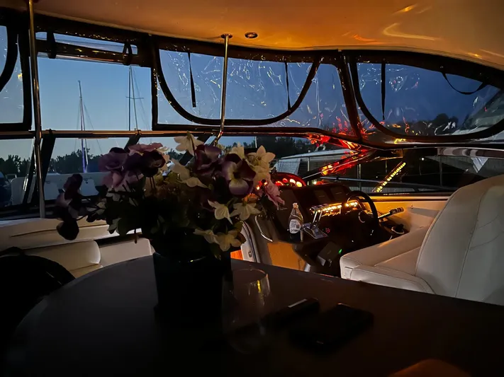  Yacht Photos Pics Interior of 2005 Regal Commodore 4260 yacht with flowers and illuminated dashboard at dusk.