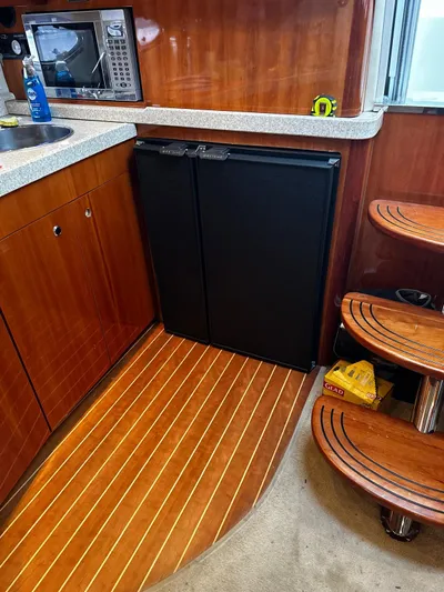  Yacht Photos Pics 2005 Regal Commodore 4260 yacht interior with wooden flooring and compact kitchen area.