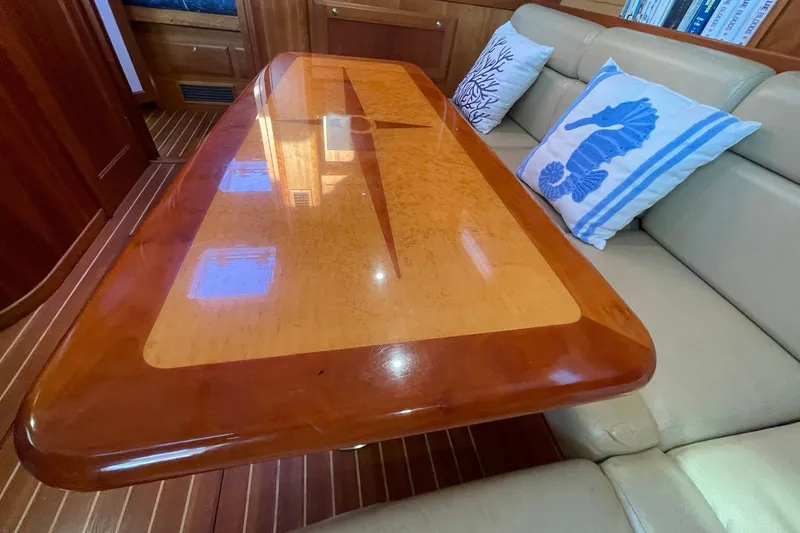 Ocean Breeze Yacht Photos Pics Luxurious interior of 2008 Sabre 38 Salon Express with elegant wooden table and nautical-themed cushions.