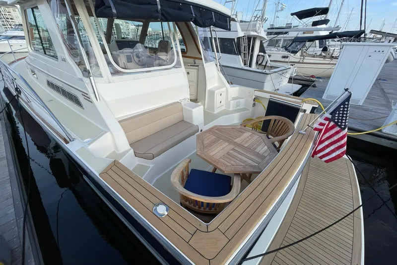 Ocean Breeze Yacht Photos Pics 2008 Sabre 38 Salon Express yacht with seating area and American flag at dock.