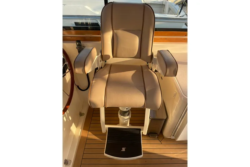 Ocean Breeze Yacht Photos Pics Captain's chair on 2008 Sabre 38 Salon Express yacht, featuring beige upholstery and wooden flooring.