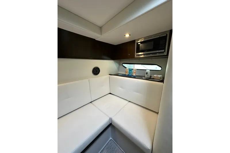 Yacht Photos Pics 2021 Cruisers Yachts 338 South Beach Edition interior with white seating and kitchenette.