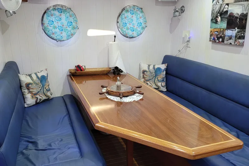No Good Deed Yacht Photos Pics Cozy interior of 2007 Great Harbour N47 yacht with blue seating and wooden table.