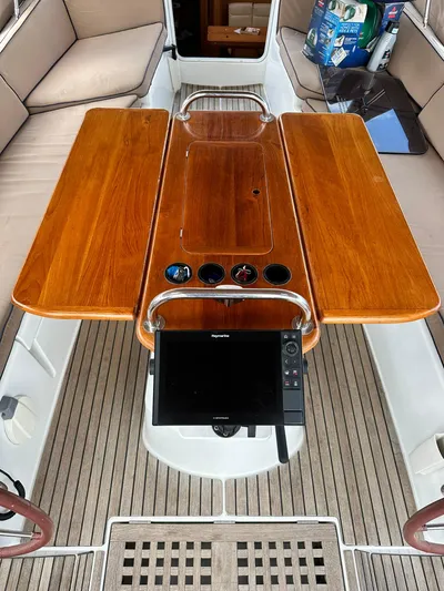  Yacht Photos Pics Cockpit of 2011 Jeanneau Sun Odyssey 45 DS with wooden table and navigation equipment.