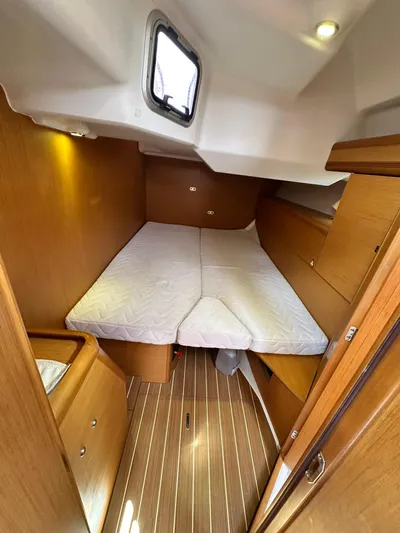  Yacht Photos Pics 2011 Jeanneau Sun Odyssey 45 DS cabin with bed, wooden interior, and porthole window.