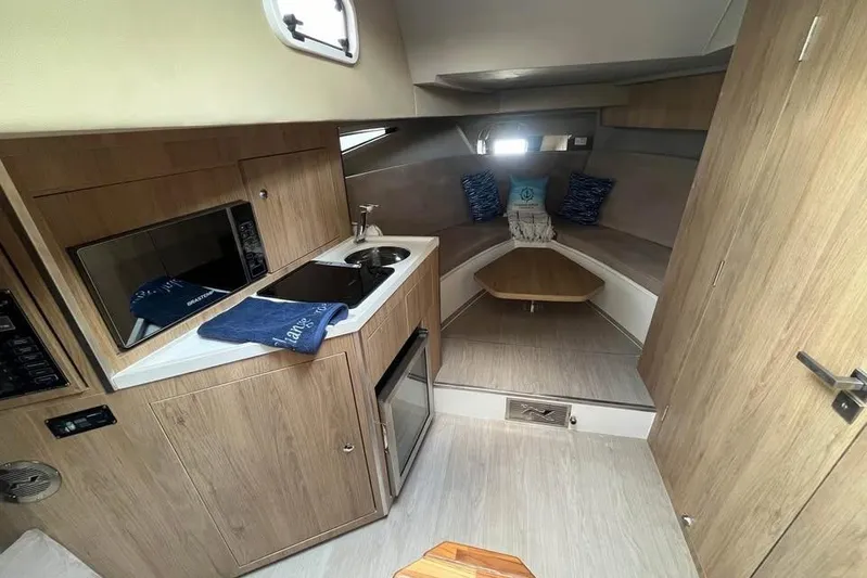  Yacht Photos Pics 2023 NX Boats 360 Sport Coupe interior with kitchenette and cozy seating area.