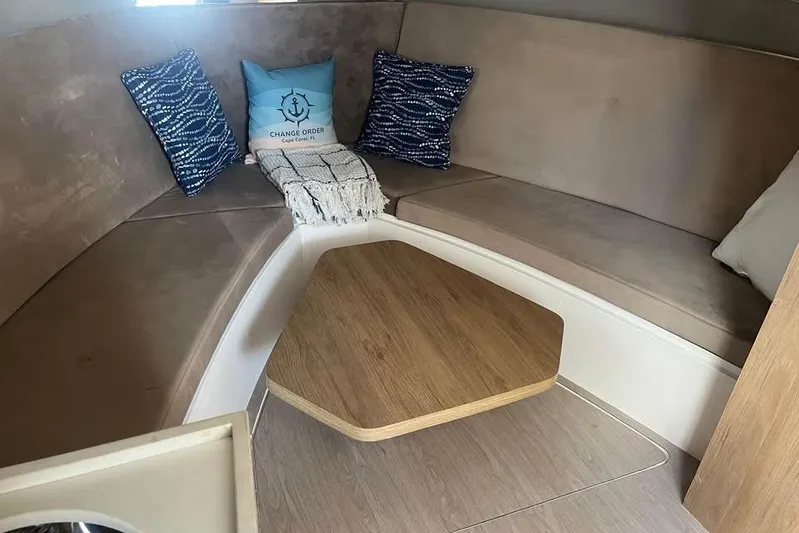  Yacht Photos Pics Interior of 2023 NX Boats 360 Sport Coupe with cozy seating and wooden table.