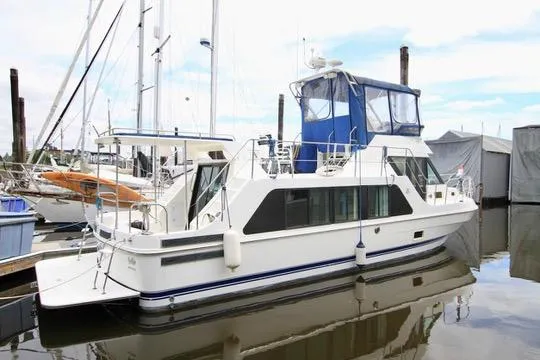 Smitten Yacht Photos Pics 2006 Harbor Master Coastal 400 yacht docked at marina, featuring blue canopy and sleek design.