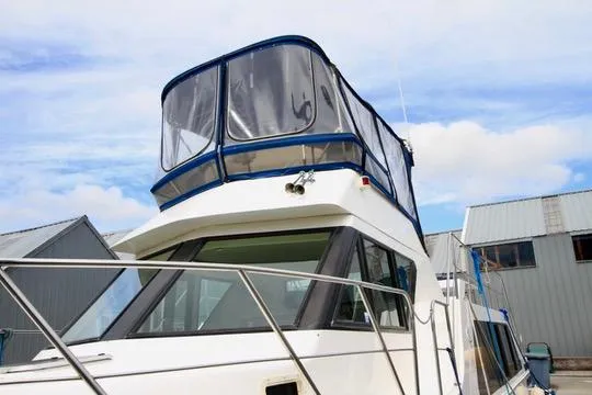 Smitten Yacht Photos Pics 2006 Harbor Master Coastal 400 boat docked near metal buildings under a blue sky.