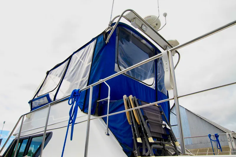 Smitten Yacht Photos Pics 2006 Harbor Master Coastal 400 boat with blue canopy and deck chairs.