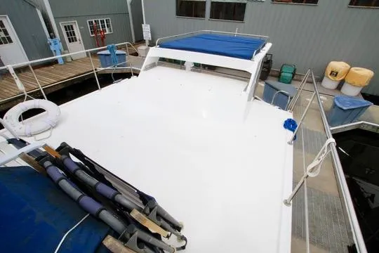 Smitten Yacht Photos Pics 2006 Harbor Master Coastal 400 boat docked, featuring spacious deck and blue canopy.