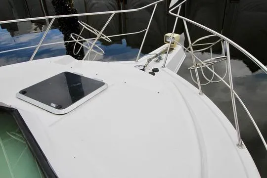 Smitten Yacht Photos Pics 2006 Harbor Master Coastal 400 boat deck with railing and hatch, docked on calm water.