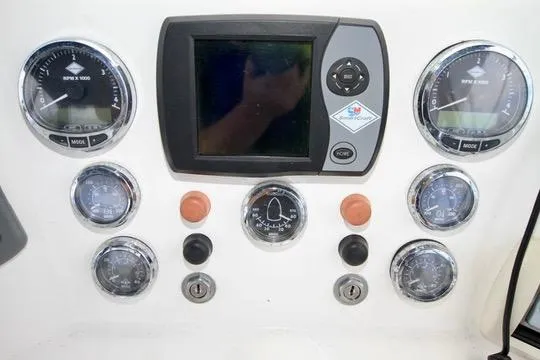 Smitten Yacht Photos Pics Control panel of a 2006 Harbor Master Coastal 400 boat with gauges and display.