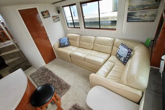 Smitten Yacht Photos Pics Luxurious interior of 2006 Harbor Master Coastal 400 with beige leather sofa and nautical decor.