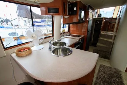 Smitten Yacht Photos Pics Interior of 2006 Harbor Master Coastal 400 yacht with kitchen and dining area.