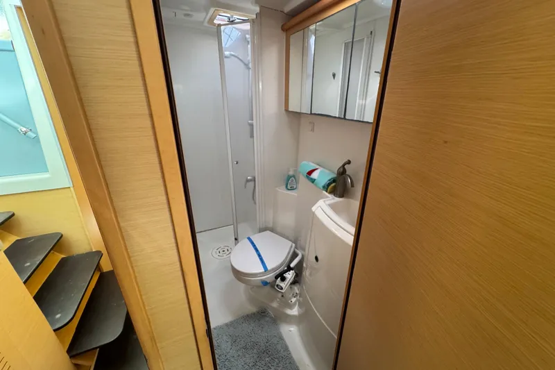 Willow Yacht Photos Pics Bathroom interior of 2008 Lagoon 420 yacht, featuring shower, toilet, and wooden cabinetry.