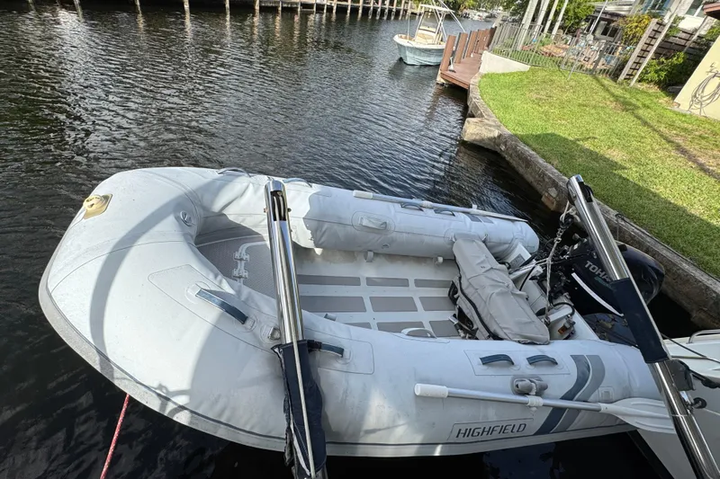 Willow Yacht Photos Pics Inflatable boat docked on a calm canal, featuring a Tohatsu outboard motor.