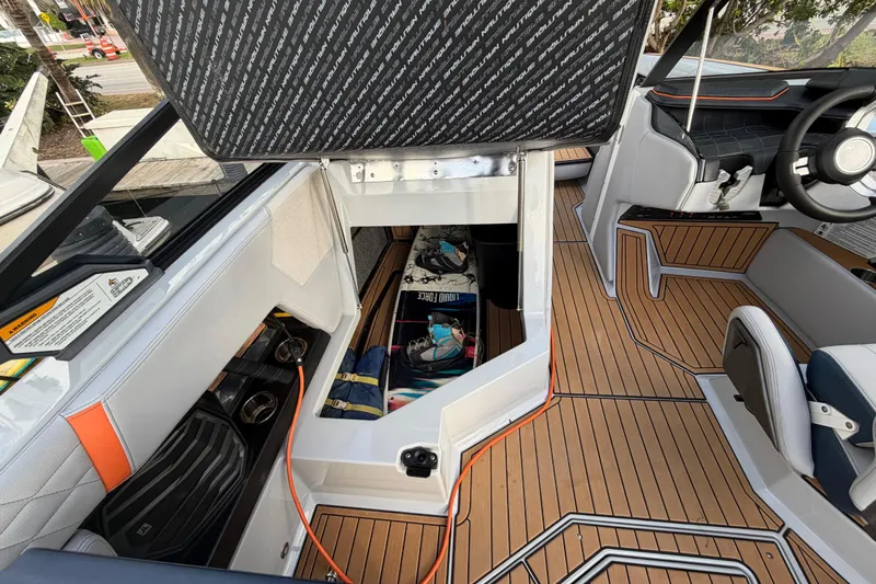 Coastal Edition Yacht Photos Pics 2022 Nautique Super Air Nautique G25 interior with open storage compartment and teak flooring.