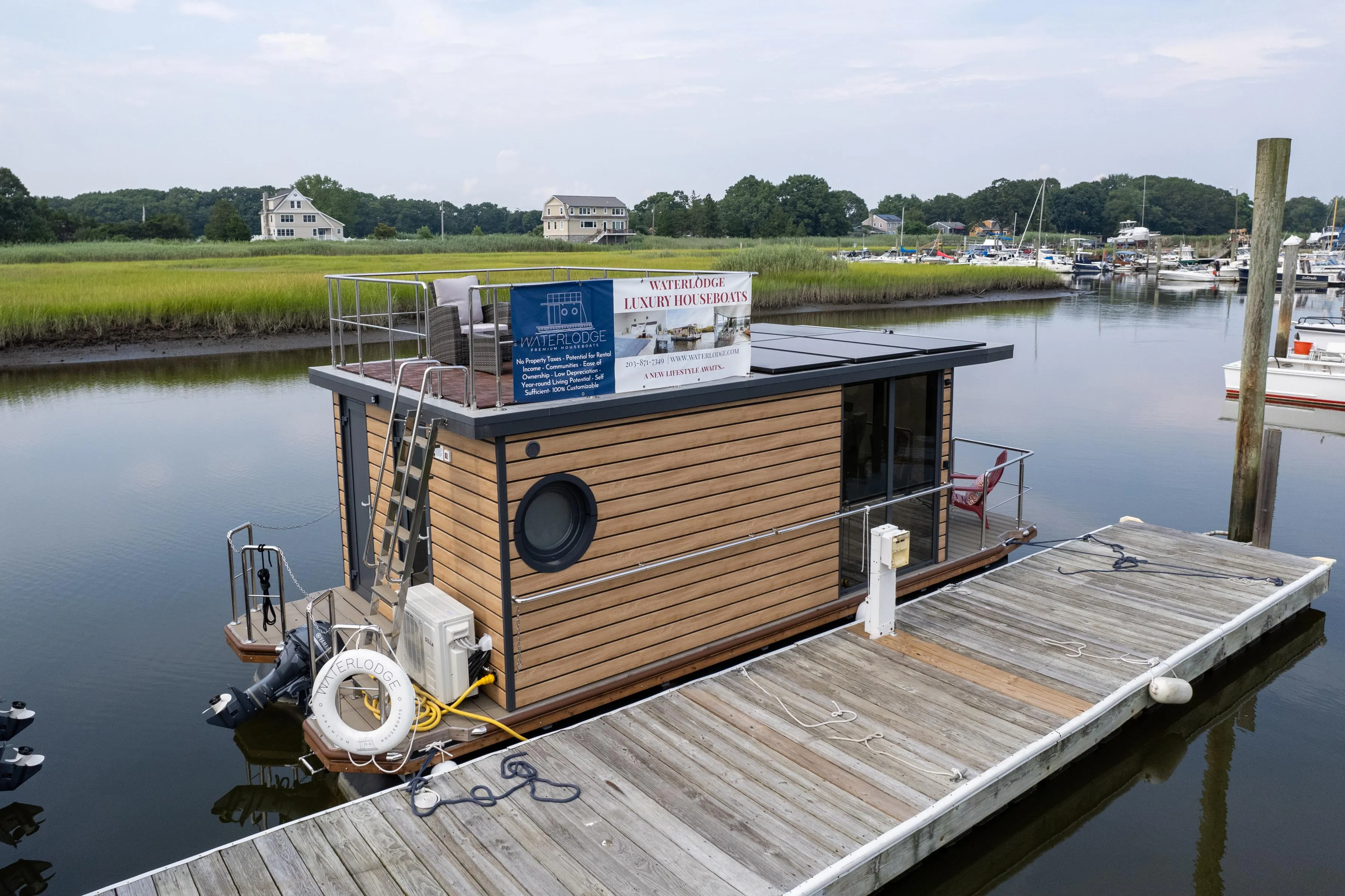 Modern 2024 Waterlodge Apart M houseboat docked in serene marina setting.