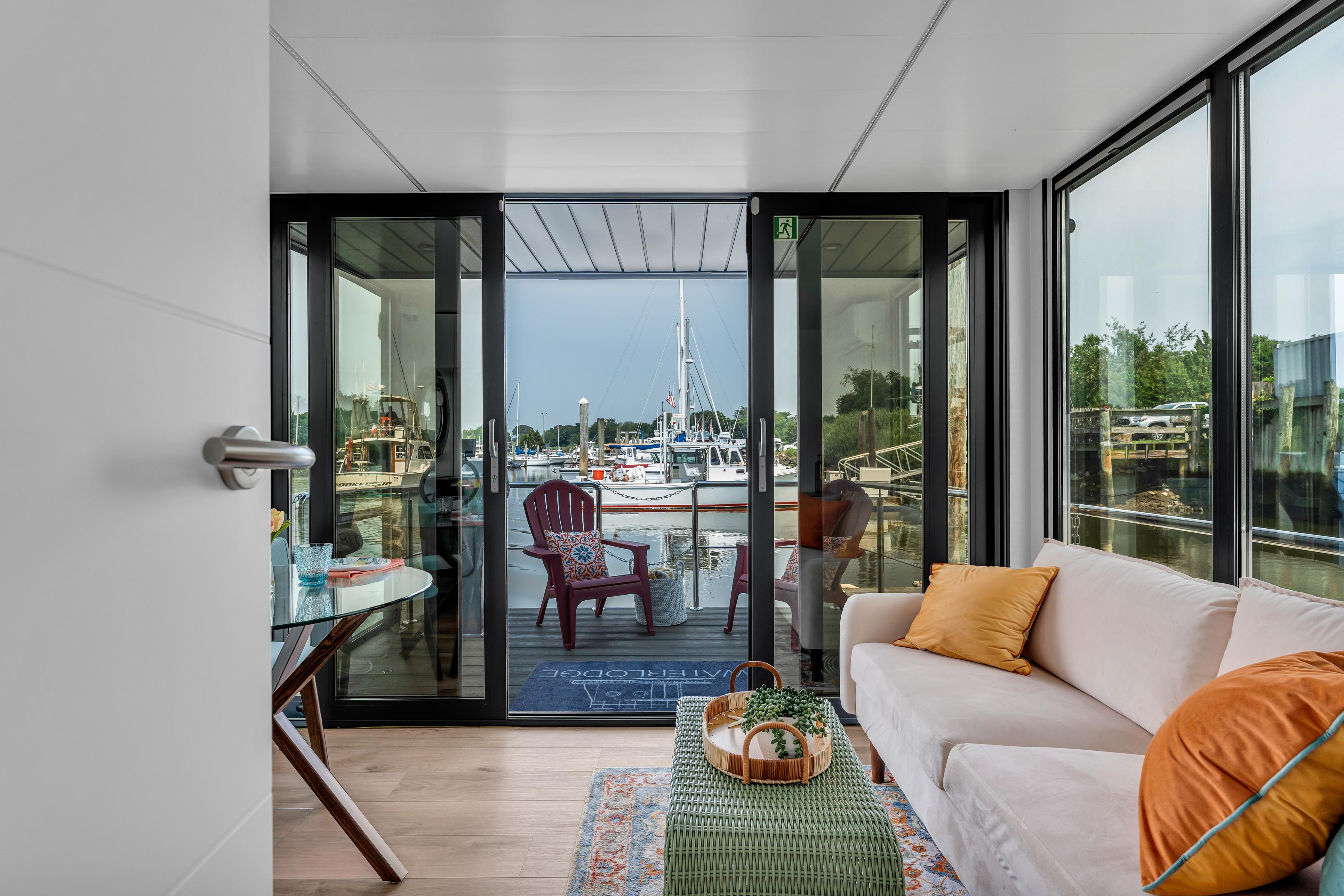 Modern Waterlodge Apart M 2024 interior with marina view, featuring cozy seating and elegant decor.