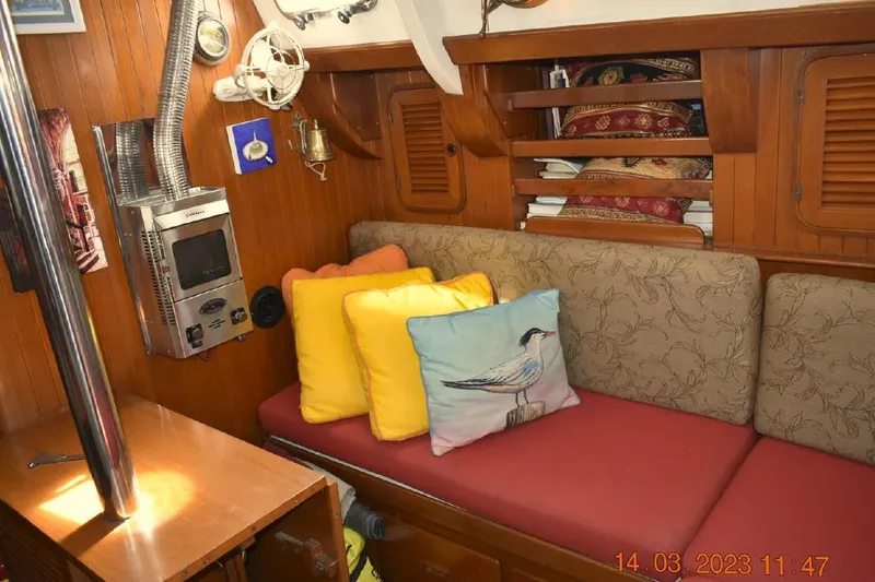 Talaria Yacht Photos Pics Cozy interior of 1988 Tayana Vancouver 42 sailboat with colorful cushions and wood paneling.