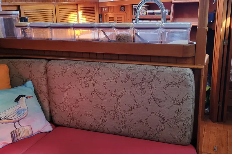 Talaria Yacht Photos Pics Cozy interior of 1988 Tayana Vancouver 42 yacht with patterned cushions and bird-themed pillow.