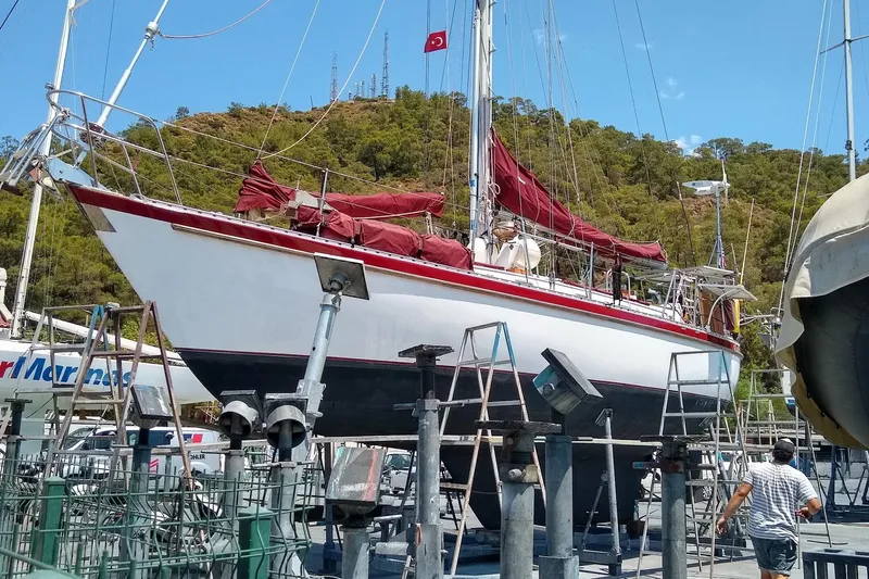 Talaria Yacht Photos Pics Sailboat Tayana Vancouver 42, 1988 model, docked for maintenance with red sails.
