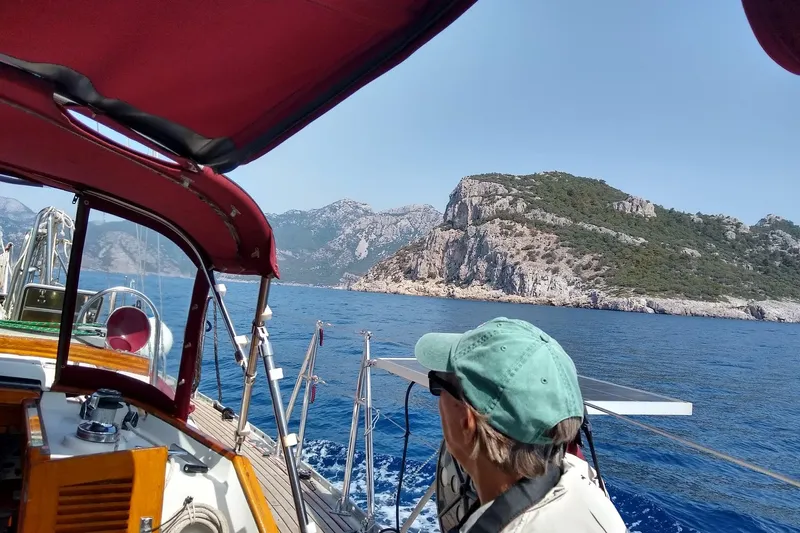 Talaria Yacht Photos Pics Sailing on a 1988 Tayana Vancouver 42 yacht near rocky coastline under clear skies.