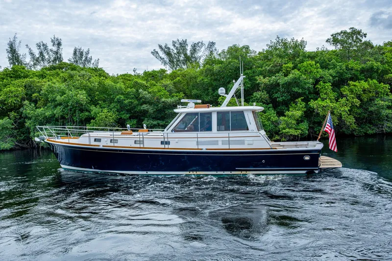 Bright Star Yacht Photos Pics 2003 Grand Banks 49 Eastbay HX yacht cruising on a serene waterway with lush greenery.