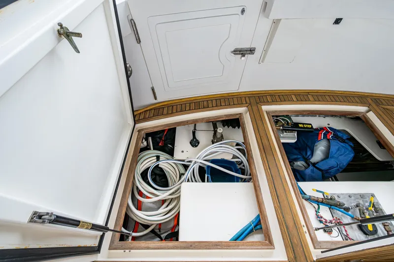 Bright Star Yacht Photos Pics Open storage compartments on 2003 Grand Banks 49 Eastbay HX boat, revealing cables and equipment.