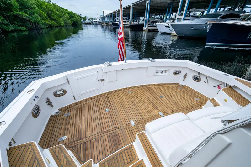 Bright Star Yacht Photos Pics 2003 Grand Banks 49 Eastbay HX yacht with teak deck, docked near lush greenery.