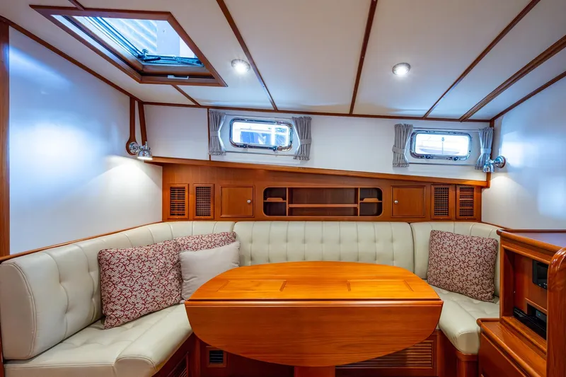 Bright Star Yacht Photos Pics Luxurious interior of 2003 Grand Banks 49 Eastbay HX yacht with elegant seating and wooden table.