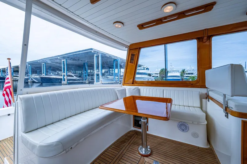 Bright Star Yacht Photos Pics Luxurious 2003 Grand Banks 49 Eastbay HX yacht interior with white seating and wooden table.