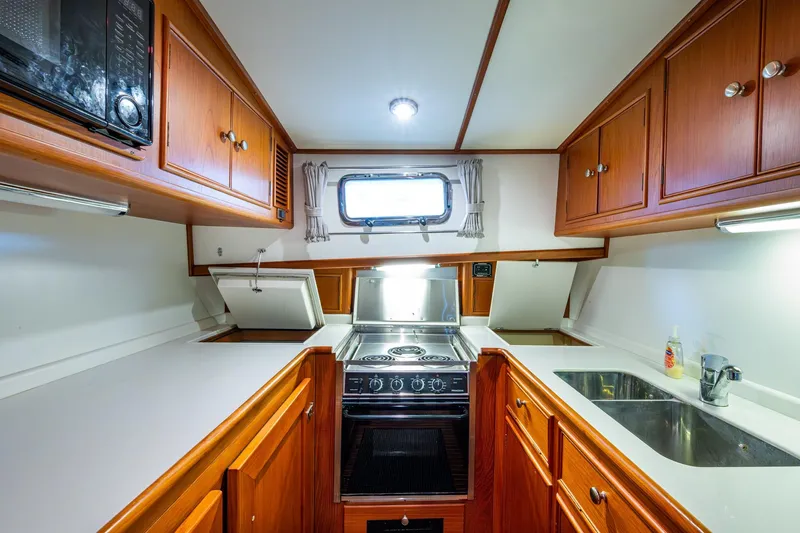 Bright Star Yacht Photos Pics 2003 Grand Banks 49 Eastbay HX yacht kitchen with wood cabinetry and modern appliances.