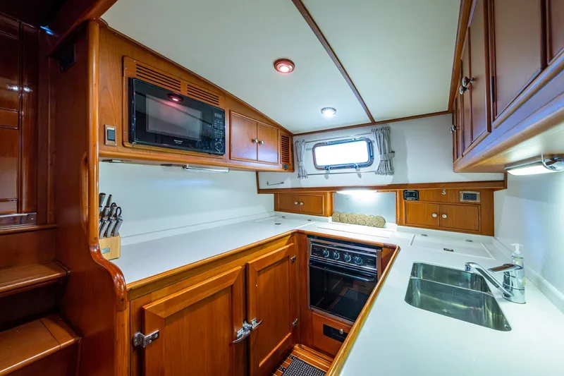 Bright Star Yacht Photos Pics 2003 Grand Banks 49 Eastbay HX yacht kitchen with wood cabinetry and modern appliances.